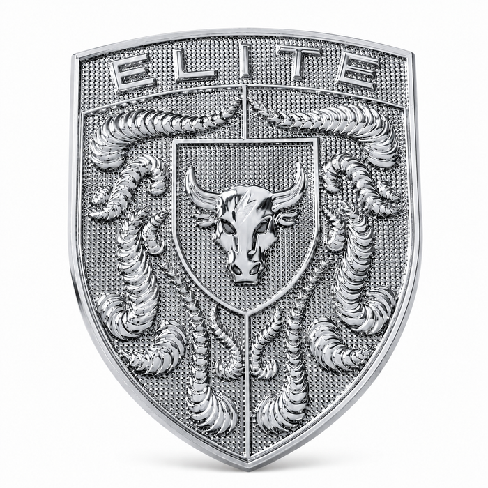 A silver-toned shield-shaped porsche emblem or badge featuring the word 'ELITE' at the top, a bull head in the center, and detailed crumrine designs on a textured background, shown on a plain light gray backdrop.