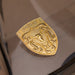 A gold metallic porsche badge with an embossed bull head and the word 'ELITE' on a glossy reflective surface.