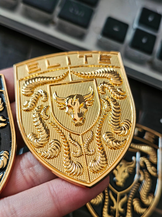 Real life image of Elite Gold Porsche Hood Emblem being held in hand.