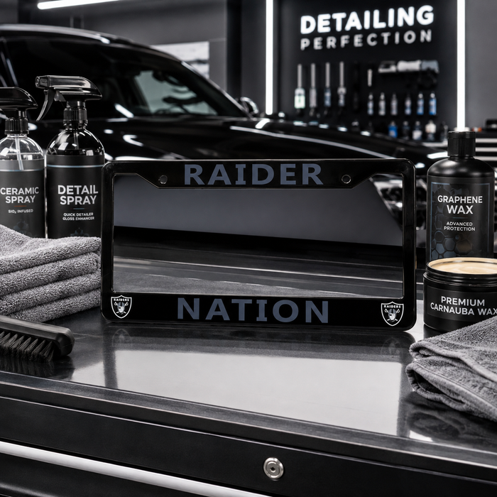 A black license plate frame with 'RAIDER' and 'NATION' in gray lettering, flanked by detailing products including Ceramic Spray, Detail Spray, Graphene Wax, and Premium Cannabwa Wax on a glossy black surface.