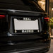Black car with 'Real Madrid' license plate frame in an indoor setting